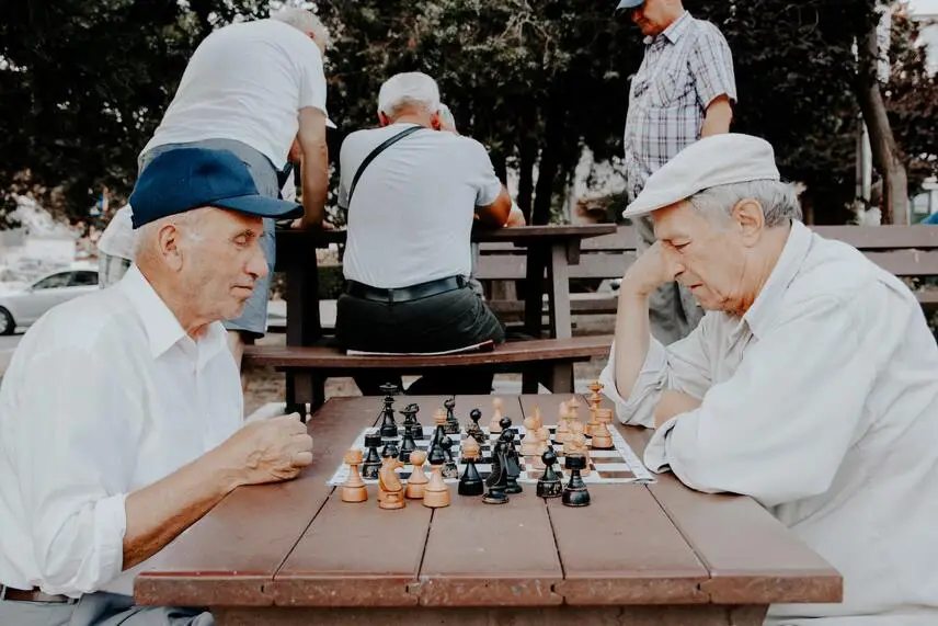 Due persone anziane che giocano a scacchi